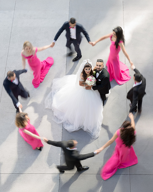 Smiling bride in white gown with CN Tower in the background, downtown Toronto.
