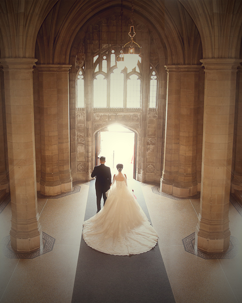 Wedding photoshoot of a bride in front of the arched windows at Knox College, Toronto.
