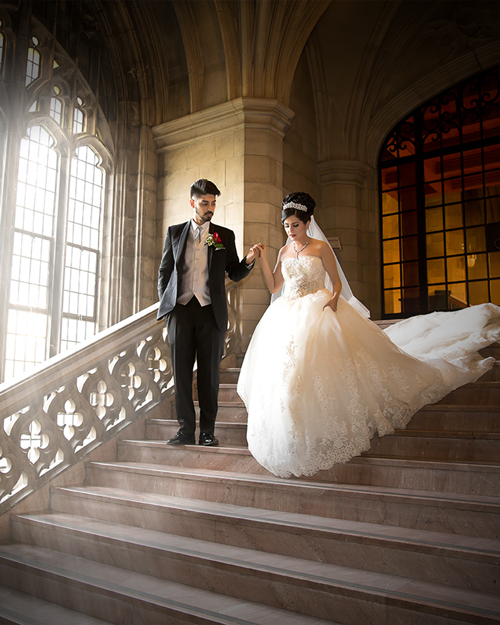 Wedding photoshoot of a bride in front of the arched windows at Knox College, Toronto.